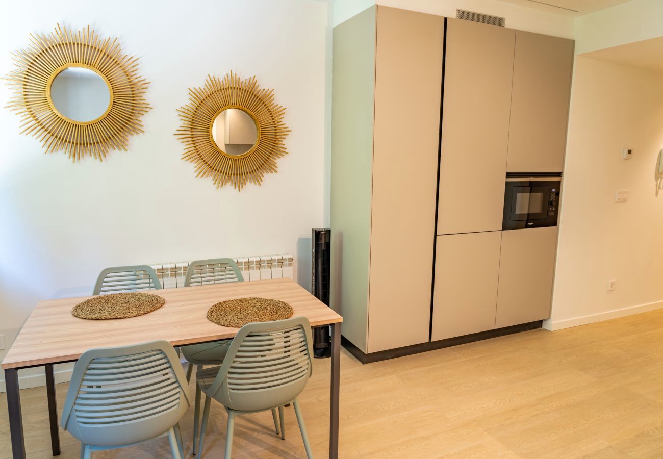 Mesa de comedor con espejos sol dorados junto a la columna de cocina