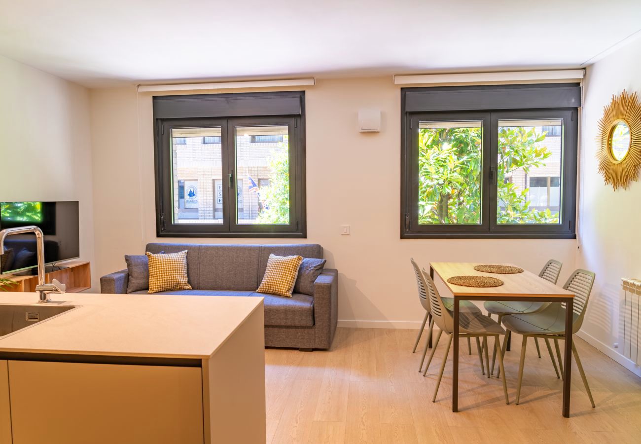 Salón con dos ventanas grandes, sofá y mesa de comedor