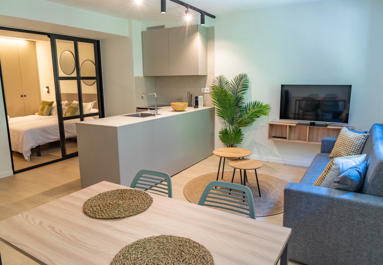 Salón abierto a la cocina con vista al dormitorio, apartamento Urban 2 habitaciones