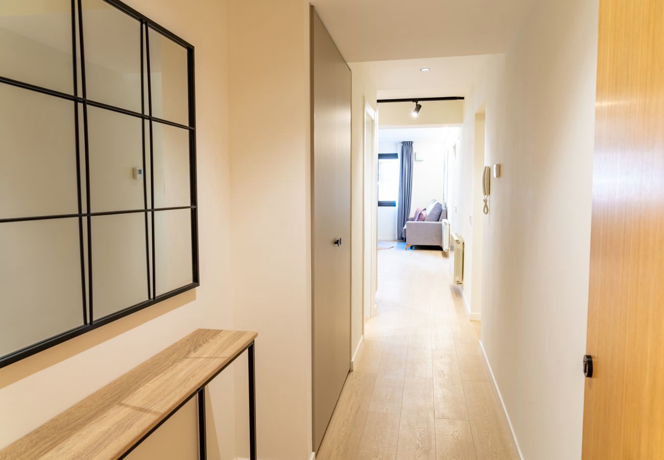 Pasillo de entrada con espejo de rejilla y consola de madera, Urban 2 habitaciones