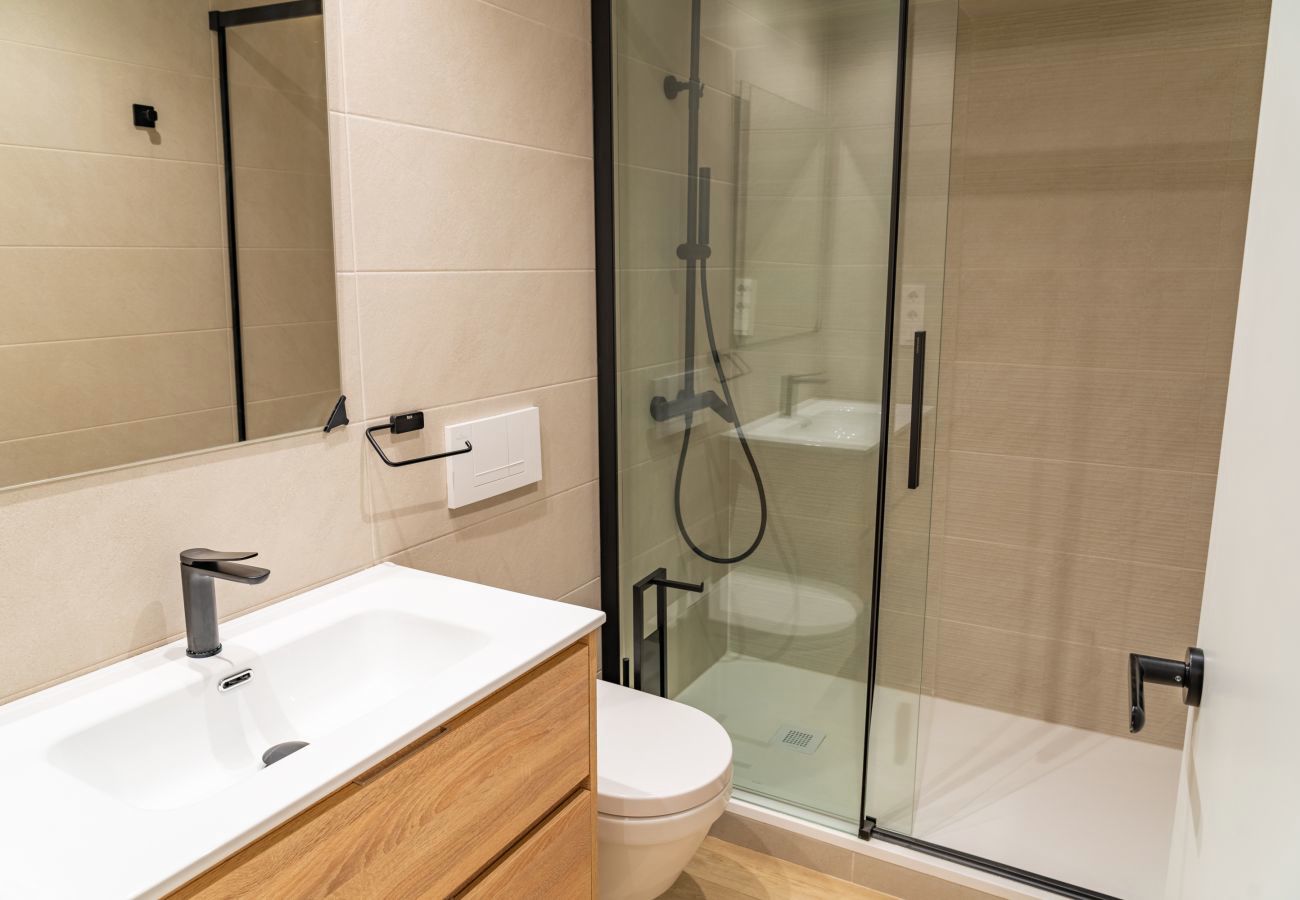 Dormitorio con tres cuadros sobre el cabecero y puerta a la zona de día, Urban 2 habitaciones