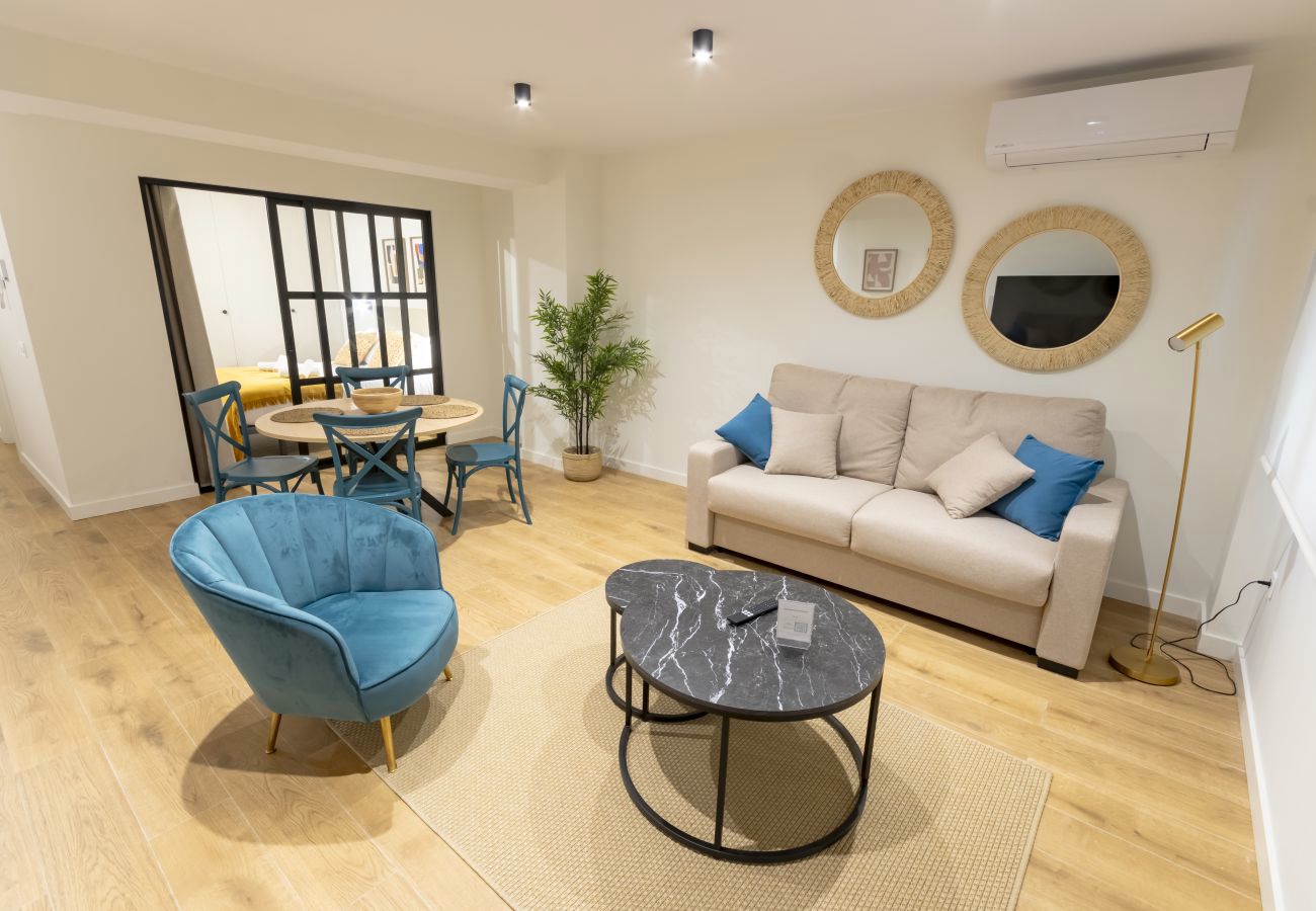Bright lounge with sofa, blue cushions and round mirrors, Superior apartment