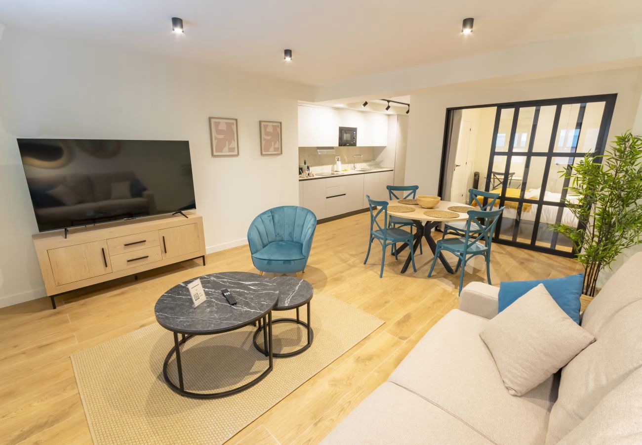 Salón con televisor, sillón y mesas de centro de mármol, apartamento Superior