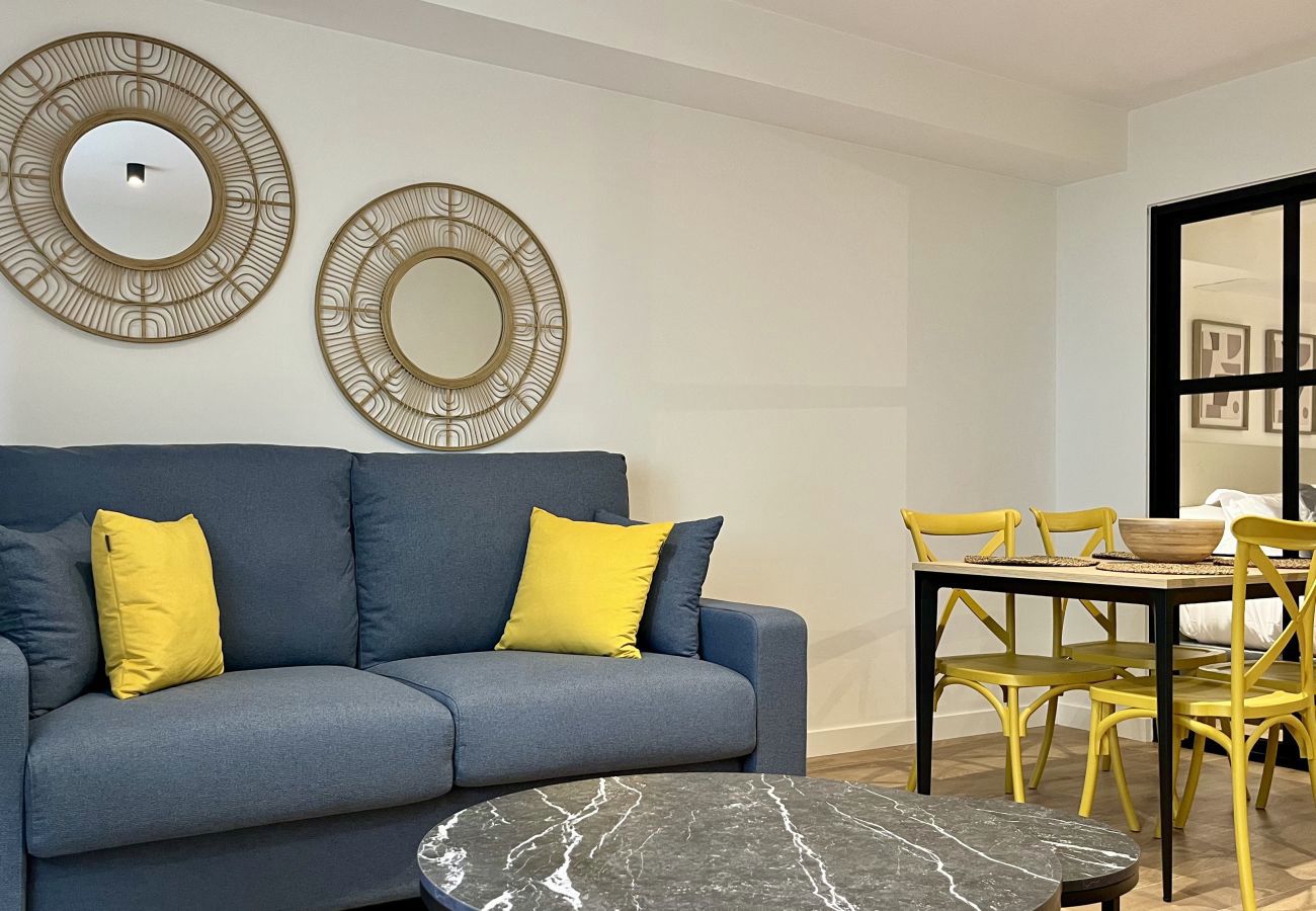 Lounge with blue sofa, mustard cushions and round mirrors, Urban Premium apartment