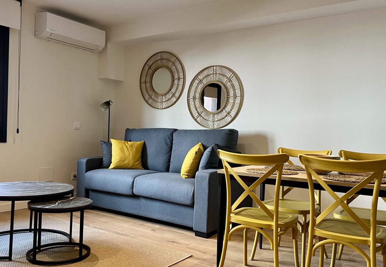 Salón con sofá azul y sillas mostaza junto a la mesa de comedor, Urban Premium