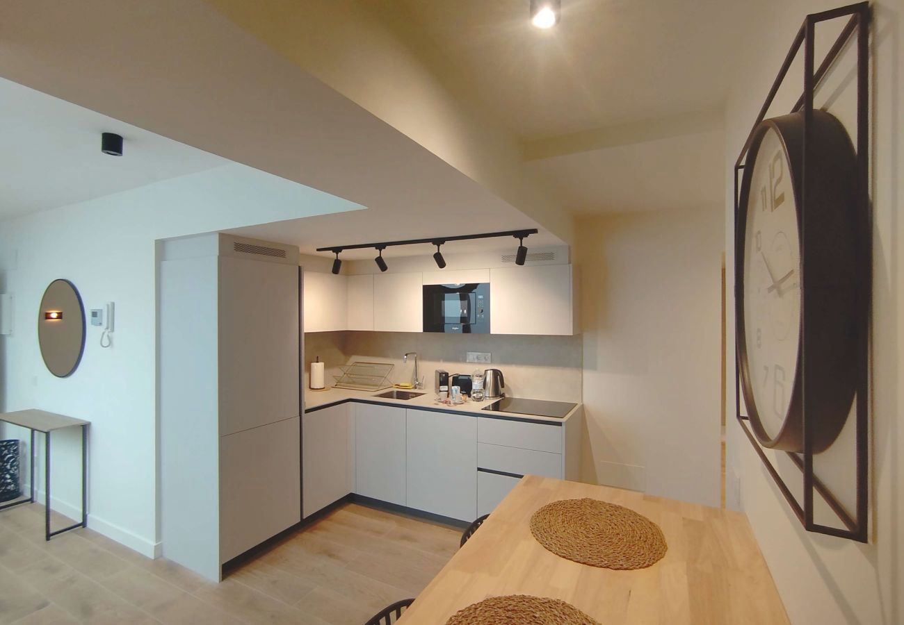 Cocina con reloj de pared grande y mesa de comedor al fondo, Urban Premium