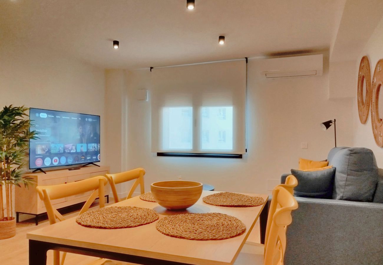 Salón con mesa de comedor y sillas mostaza junto a la cocina, Urban Premium