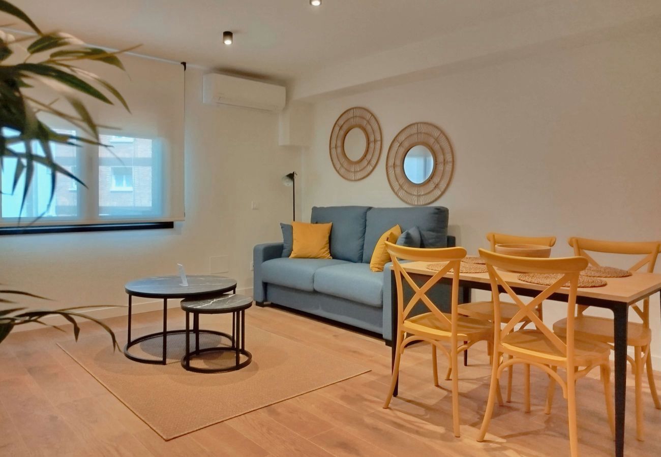 Salón con sofá, espejos redondos y mesa de comedor con sillas mostaza, Urban Premium