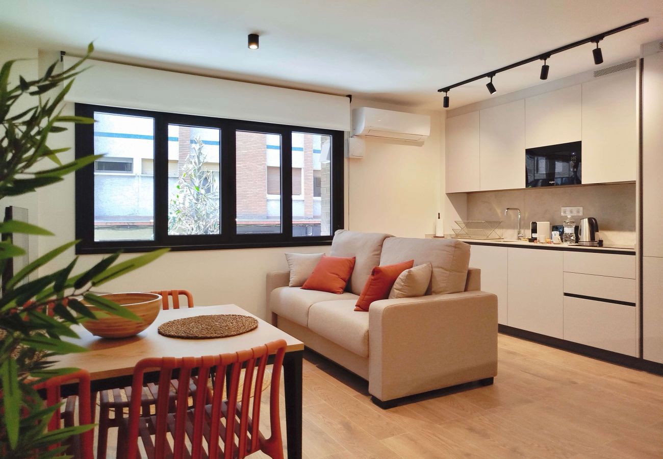Salón con sofá y sillas terracota junto a la mesa de comedor, Urban Suite