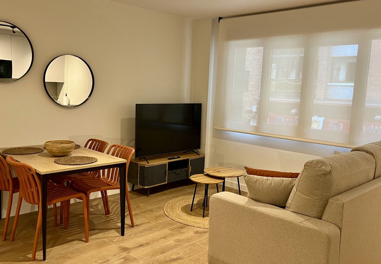 Lounge with two round mirrors, TV and dining table, Urban Suite apartment