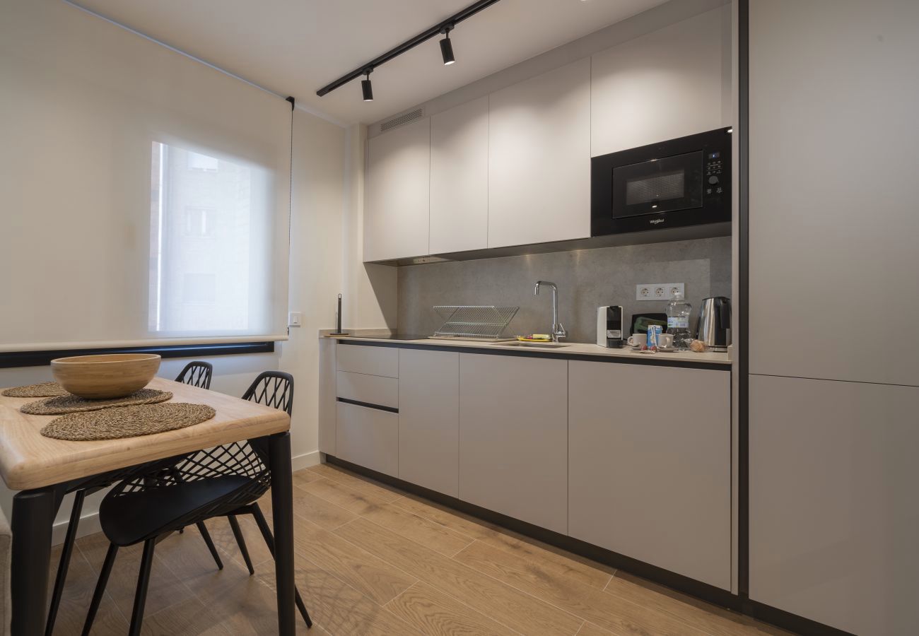 Cocina con muebles claros y mesa de comedor con sillas negras, Urban Suite