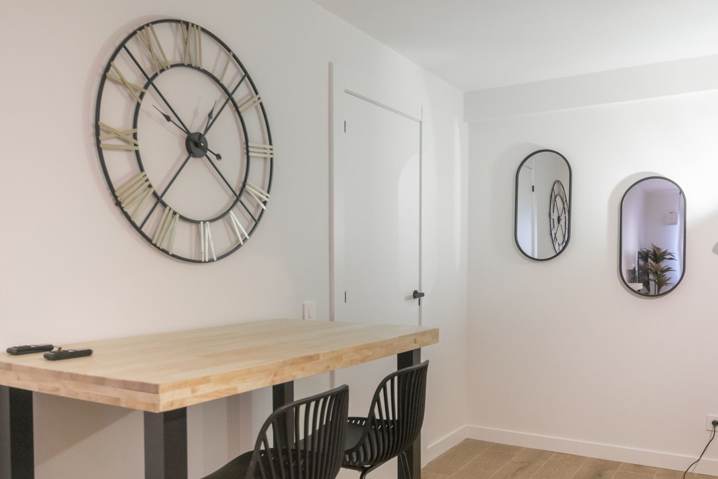 Barra alta con taburetes y reloj de pared junto a la cocina, apartamento Urban Superior