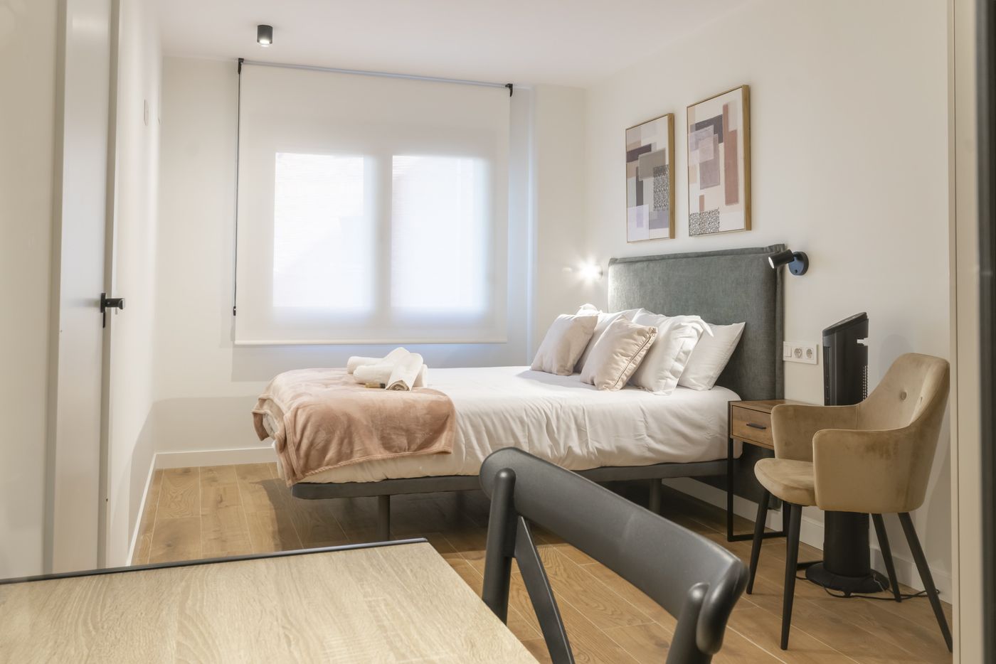 Dormitorio con cama de matrimonio y escritorio de trabajo con silla, apartamento Urban Superior