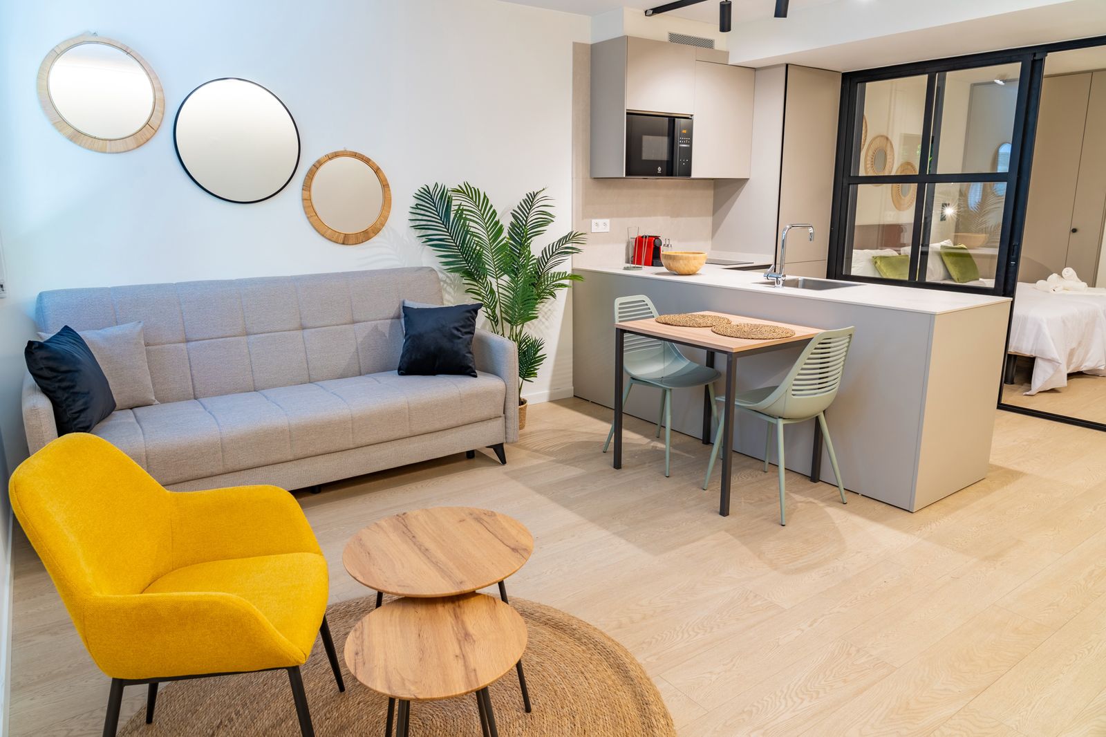 Lounge with mustard armchair, round mirrors and dining corner