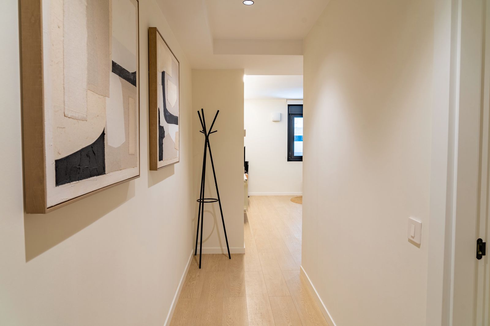 Entrance hallway with abstract artwork and a freestanding coat rack